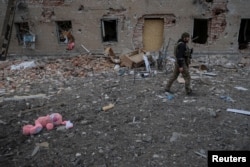 Украинский военный у одного из разрушенных домов в городе Часов Яр