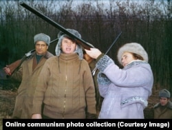 Nicolae Ceausescu, sporting a bandaged trigger finger, watches his wife, Elena, take aim with a shotgun during a New Year’s Eve hunting trip in 1976.