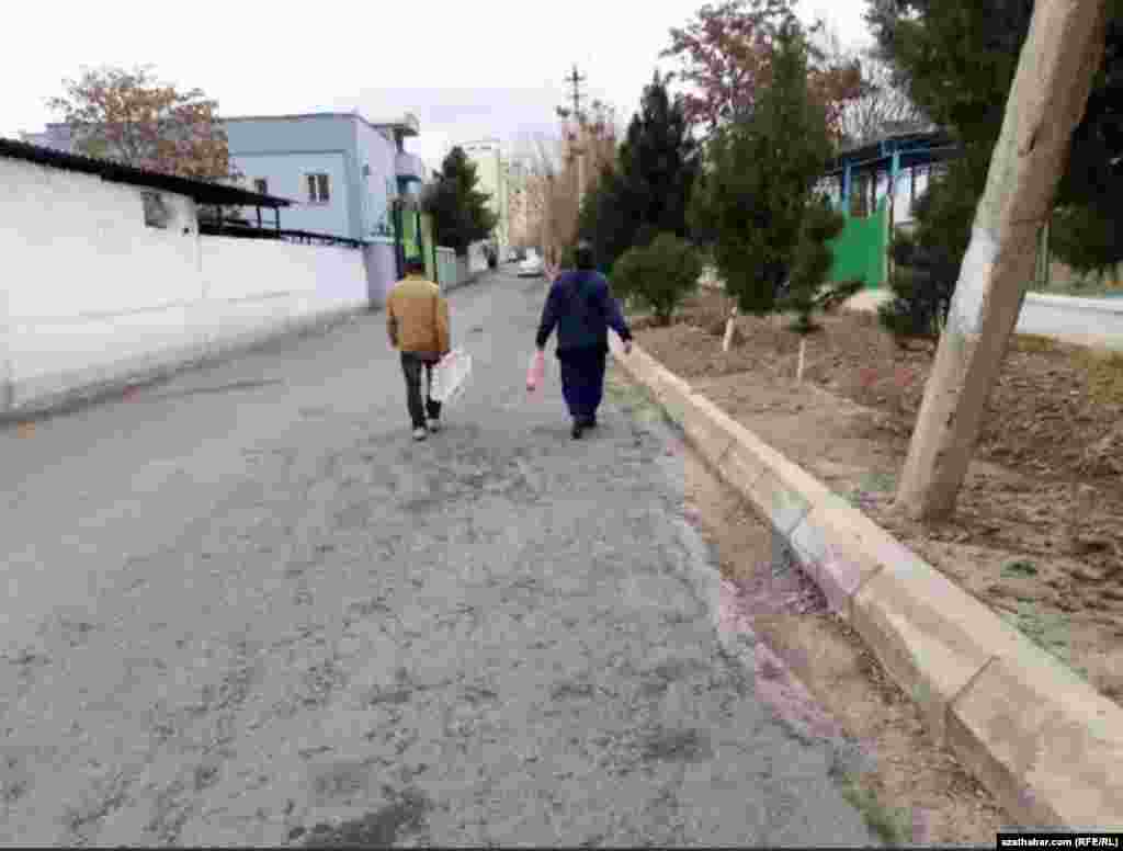 Aşgabadyň köçeleriniň birinden ýöräp barýan adamlar.