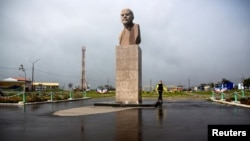 A woman walks past a statue of Soviet state founder Vladimir Lenin in Yuzhno-Kurilsk, the main settlement on the Southern Kurile island of Kunashir. (file photo)