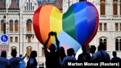 People gather in front of a huge rainbow balloon put up by members of Amnesty International and Hatter, an NGO promoting LGBT rights, outside Hungary's parliament in Budapest on July 8.