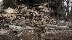 A Ukrainian police officer assisting people evacuated from front-line towns and villages checks an area for residents in Dobropillia in the Donetsk region on December 9. 