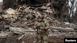 A Ukrainian police officer assisting people evacuated from front-line towns and villages checks an area for residents in Dobropillia in the Donetsk region on December 9. 