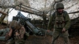 FILE PHOTO: Ukrainian servicemen fire a self-propelled howitzer towards Russian troops near the frontline town of Pokrovsk