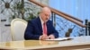 Александр Лукашенко подписывает документ после присяги