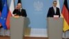 German Chancellor Olaf Scholz (left) and Polish Prime Minister Mateusz Morawiecki talk to reporters in Warsaw on December 12. 