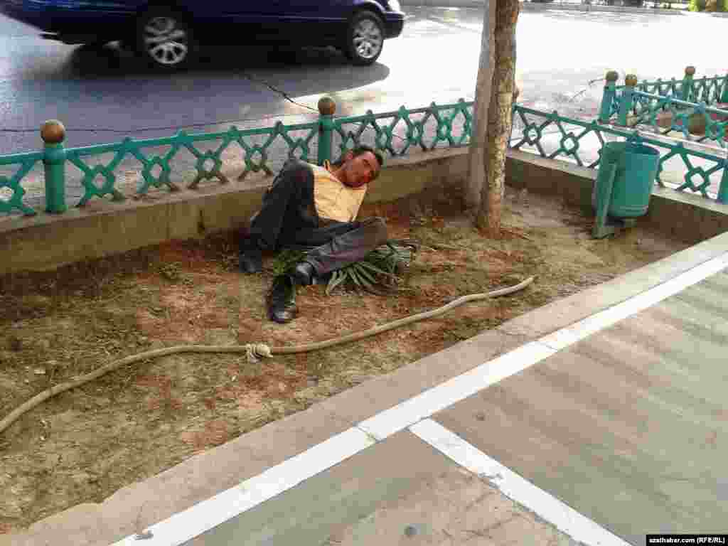 Serhoş bir adam köçäniň gyrasynda ýatyr