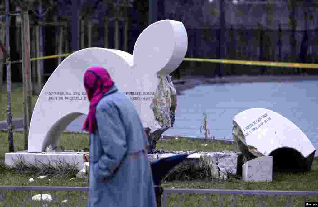 A woman walks past a destroyed monument in the southern Bosnian city of Mostar, 100 kilometers from the capital, Sarajevo. A bomb blast destroyed the monument to fallen soldiers of Bosnia&#39;s Muslim-dominated wartime army in Mostar, where divisions between ethnic Croats and Muslims still run deep. (Reuters/Dado Ruvic)