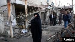 People gather at the site of a bomb attack in the Ur district of northeastern Baghdad on February 18.