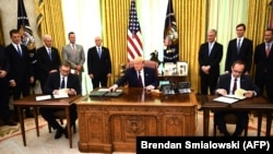 Претседателот на САД Доналд Трамп со косовскиот премиер Авдулах Хоти (Д) и српскиот претседател Александар Вучиќ (Л) на потпишувањето на договорот за економски односи, во Овалната соба на Белата куќа во Вашингтон, 4 септември 2020 година