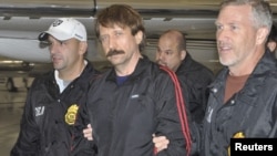 Convicted Russian arms dealer Viktor Bout (center) is escorted by U.S. Drug Enforcement Administration officers after arriving in the United States following his extradition from Thailand last year. 