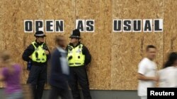 Patrulă de poliţie în faţa vitrinei sparte a unui magazin