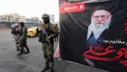 Members of the Iranian police stand guard on a street in Tehran, next to a large banner featuring Iran's late Supreme Leader Ayatollah Ali Khamenei on March 12. 
