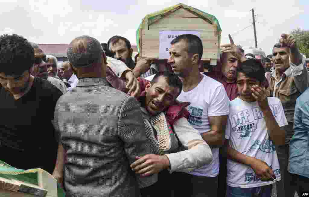 Kurdish mourners cry as they carry coffins on the outskirts of the majority Kurdish city of Diyarbakir, Turkey, after a massive explosion hit the area. The blast was caused after a huge quantity of explosives hoarded by Kurdish rebels blew up accidentally. (AFP/Ilyas Akengin)