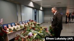 UKRAINE -- An airport employee looks at a makeshift memorial inside Borispil international airport in Kyiv, January 10, 2020