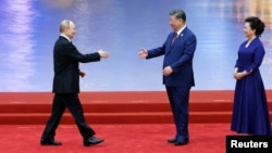 Chinese leader Xi Jinping and his wife Peng Liyuan welcome Russian President Vladimir Putin during a ceremony at the Shanghai Cooperation Organization (SCO) summit in Tianjin in August 2025.