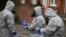 Military personnel wearing protective coveralls work to remove vehicles from a cordoned off area in Salisbury where a former Russian spy and his daughter were found poisoned last week. 