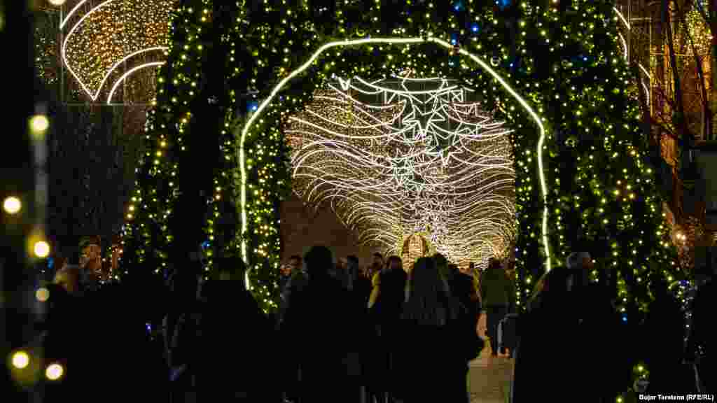 Njerëzit në sheshin e ndriçuar të kryeqytetit të Kosovës shijojnë atmosferën festive këtë fundvit.