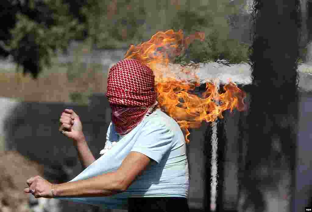 A Palestinian protester sets fire to himself as he throws a Molotov cocktail during clashes with members of the Israeli armed forces in the West Bank city of Hebron. The past two weeks have seen the worst spell of street violence in Israel and the Palestinian areas in years, stirred in part by Muslim anger over perceived changes to the status quo observed at a disputed Jerusalem holy site. (epa/Abed Al Hashlamoun)