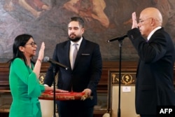 Дельси Родригес приносит присягу в качестве временного президента Венесуэлы перед своим братом, председателем Национальной ассамблеи Хорхе Родригесом (справа) и депутатом Николасом Мадуро Геррой (в центре), сыном захваченного США бывшего лидера. Каракас, 5 января 2026 года