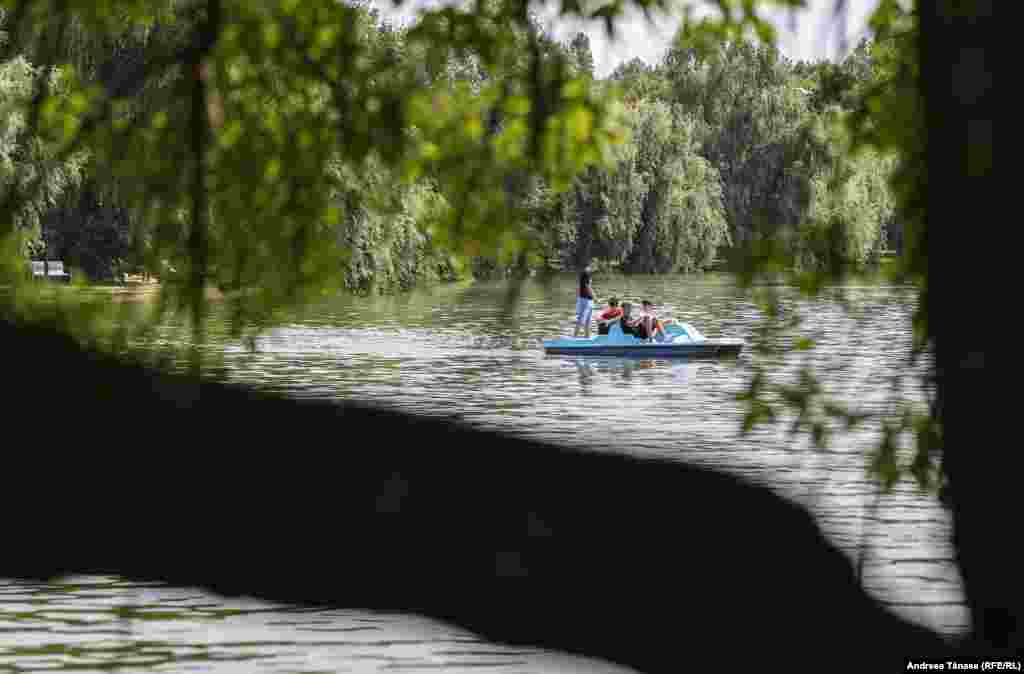 Tineri se plimbă cu hidrobicicleta pe lacul din Parcul Alexandru Ioan Cuza din București.