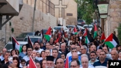 Creștini palestinieni din satul Jifna, la nord de Ramallah, in Cisiordania, își exprimă solidaritatea cu palestinenii din Gaza la 23 octombrie 2023, pe fondul luptelor dintre Forța de Apărare Israeliană și milițiile Hamas. (Foto: AFP) 