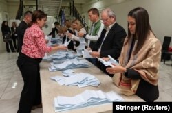 Membrii unei comisii electorale numără buletinele de vot într-o secție de vot din Chișinău, 28 septembrie 2025.