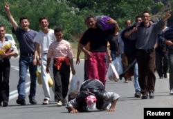 Refugjatë kosovarë duke kaluar kufirin në Kosovë, në qytetin e Hanit të Elezit, më 14 qershor 1999.