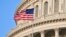 U.S. – Capitol Building dome detail with US flag waving.