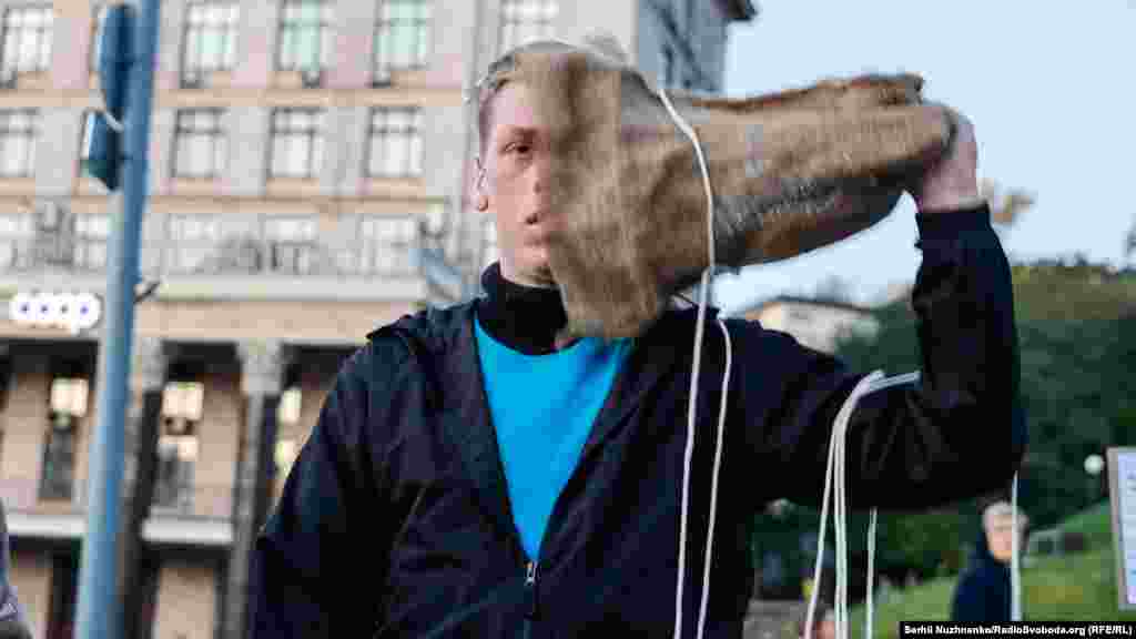 Во время акции молодой человек, изобразивший политузника, снял мешок с головы