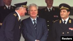 Slobodan Milošević u društvu kasnije osuđenih ratnih zločinaca - Nebojše Pavkovića (desno) i Dragoljuba Ojdanića (levo) - na vojnoj paradi u Beogradu, septembar 2000. godine, mesec dana uoči pada režima.