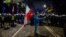 Чоловік із державним прапором Польщі позує перед поліцейським кордоном, тоді як протестувальники збираються біля будівлі Конституційного суду Польщі у Варшаві — після того, як 31 жовтня 2026 року поліція перекрила доступ до цієї будівлі