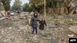 Olga Mudra sa 6-godišnjom kćeri Natalijom pored njihove stambene zgrade u Kijevu, koja je oštećena u masovnom ruskom napadu raketama i dronom 2. juna.