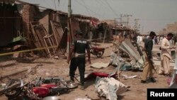 Pakistani police and security officials collect evidence at the site of a bomb blast in Dera Allah Yar, located in the Jaffarabad district of Balochistan Province, on March 22.