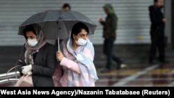 Iranian women wear protective masks to prevent contracting coronavirus, as they walk in the street in Tehran, Iran February 25, 2020.