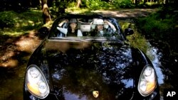 In this picture taken on Friday, May 24, 2013, two Iranian women ride in a Porsche, in Noor forest, northern Iran. (AP Photo/Ebrahim Noroozi)