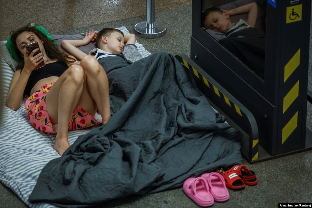 Një grua dhe një djalë të shtrirë në dyshemenë e një stacioni metroje, gjatë një alarmi për bombardime, më 8 korrik.