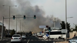 Șoferii trec pe lângă o coloană de fum care se ridică în urma unui atac iranian raportat în districtul industrial din Doha, Qatar, pe 1 martie.