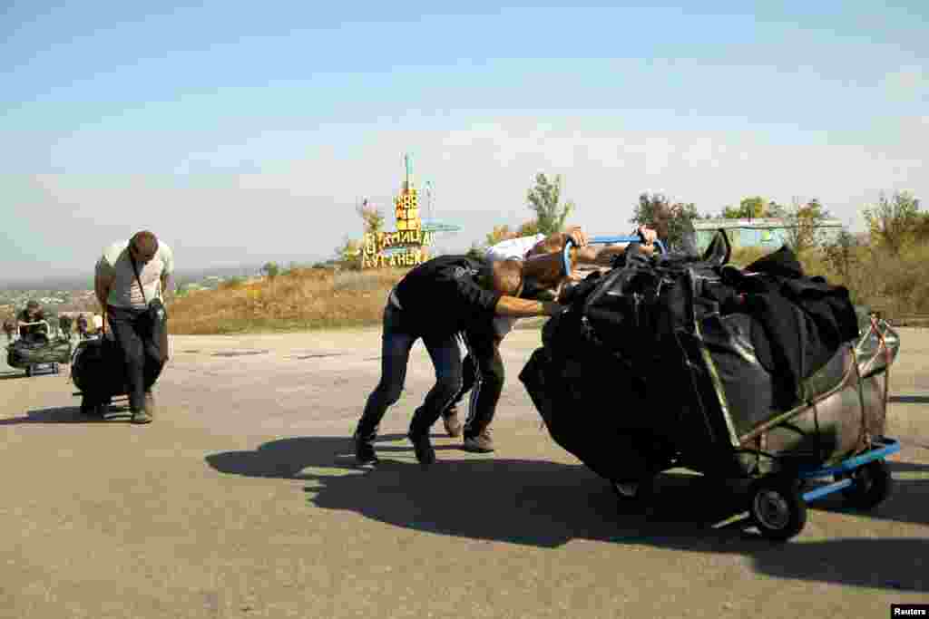 Люди йдуть по дорозі між двома пунктами пропуску, проросійських бойовиків та українських військових, в селищі Станиця Луганська. Українські військові заявляють, що нині неможливо здійснити передбачене останніми домовленостями розведення сил на трьох ділянках лінії контакту на сході України через те, що російсько-сепаратистські сили не припиняють обстрілів і не забезпечують вільного пересування патрулям ОБСЄ. Станиця Луганська, Луганська область, 1 жовтня 2016 року БІЛЬШЕ ПРО ЦЕ