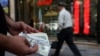 A currency dealer holds $100 bills, as the value of the Iranian rial drops, in Tehran, Iran on May 2.