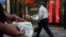 A currency dealer holds $100 bills, as the value of the Iranian rial drops, in Tehran, Iran on May 2.