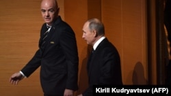 Russian President Vladimir Putin (right) and FIFA President Gianni Infantino walk on stage ahead of the 2018 FIFA World Cup football tournament final draw at the State Kremlin Palace in Moscow on December 1.