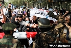 Talibanski borci ispred demonstranata koji traže prava žena i protestuju protiv talibana u Kabulu 7. septembra.