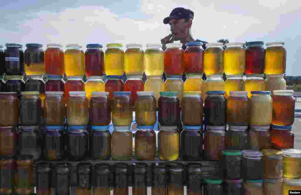 A vendor, who is also a beekeeper, sells honey at a roadside market north of Astana, Kazakhstan. (Reuters/Shamil Zhumatov)