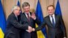 Ukrainian President Petro Poroshenko (center) shakes hands with European Commission President Jean-Claude Juncker (left) and European Council President Donald Tusk at the EU Council in Brussels on March 17.