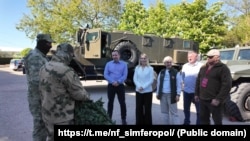  Руски военни получават камуфлажни мрежи от санаториума „ Северное зарево “ в Саки по време на пълномащабната съветска инвазия в Украйна, май 2025 година 