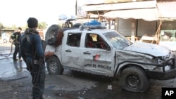 Security personnel inspect the site of a suicide attack on the outskirts of the eastern city of Jalalabad on June 13.