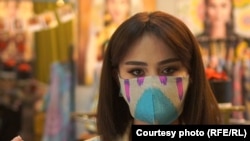 A woman wears a face mask made from traditional Tajik fabric by local designer Nafisa Imronova in response to soaring demand in the Central Asian country for facial coverings.