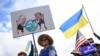 Demonstrators wave flags and hold signs as they rally in support of Ukraine along Seward Highway in Anchorage, Alaska, on August 14, 2025, on the eve of the scheduled meeting between the US and Russian presidents.