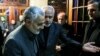 Quds Force commander Qasem Soleimani (left) is welcomed by Foreign Minister Mohammad Javad Zarif to the funeral of Zarif's mother in 2013.